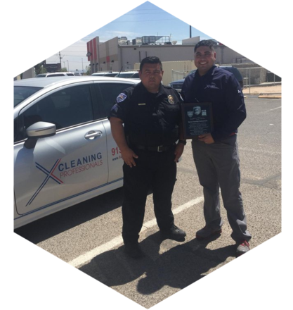 Two police officers standing in front of a police car.