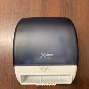 A blue and white X Automatic Towel Dispenser sitting on a wooden floor.